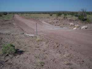 This is the main drag to the county road. Technically it's all private property, tended by a sort of vestigial property-owners' association that rarely gets involved with anything but road maintenance. The road guy tried to keep this little wash crossing passable with culverts that kept washing out. Finally he just dug the culverts out and half-ass paved it. So far that has worked.